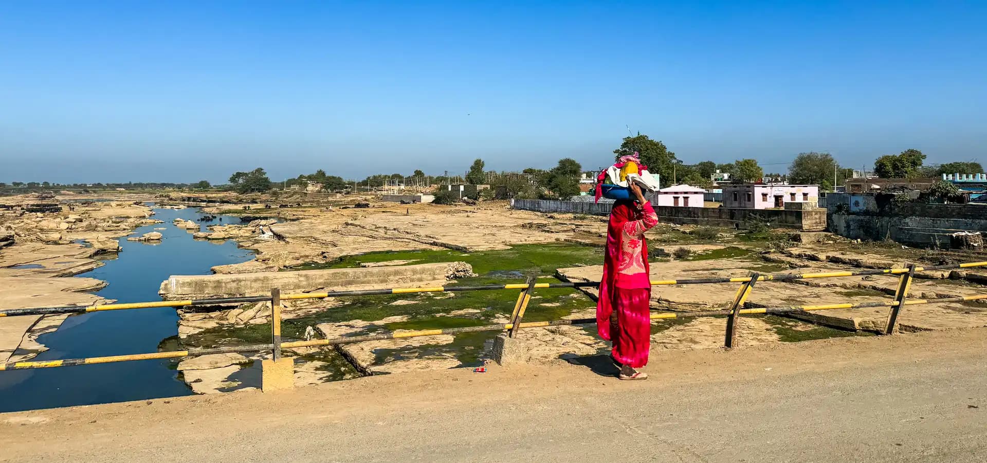 Motorreis door Centraal-India met Indian Rides Vrouw in traditionele kleding langs een rivier tijdens een motorreis door Centraal-India met Indian Rides